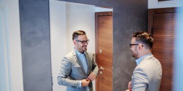 Man in suit practicing interview skills in front of the mirror