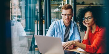 man and woman with lap top tracking progress towards goals